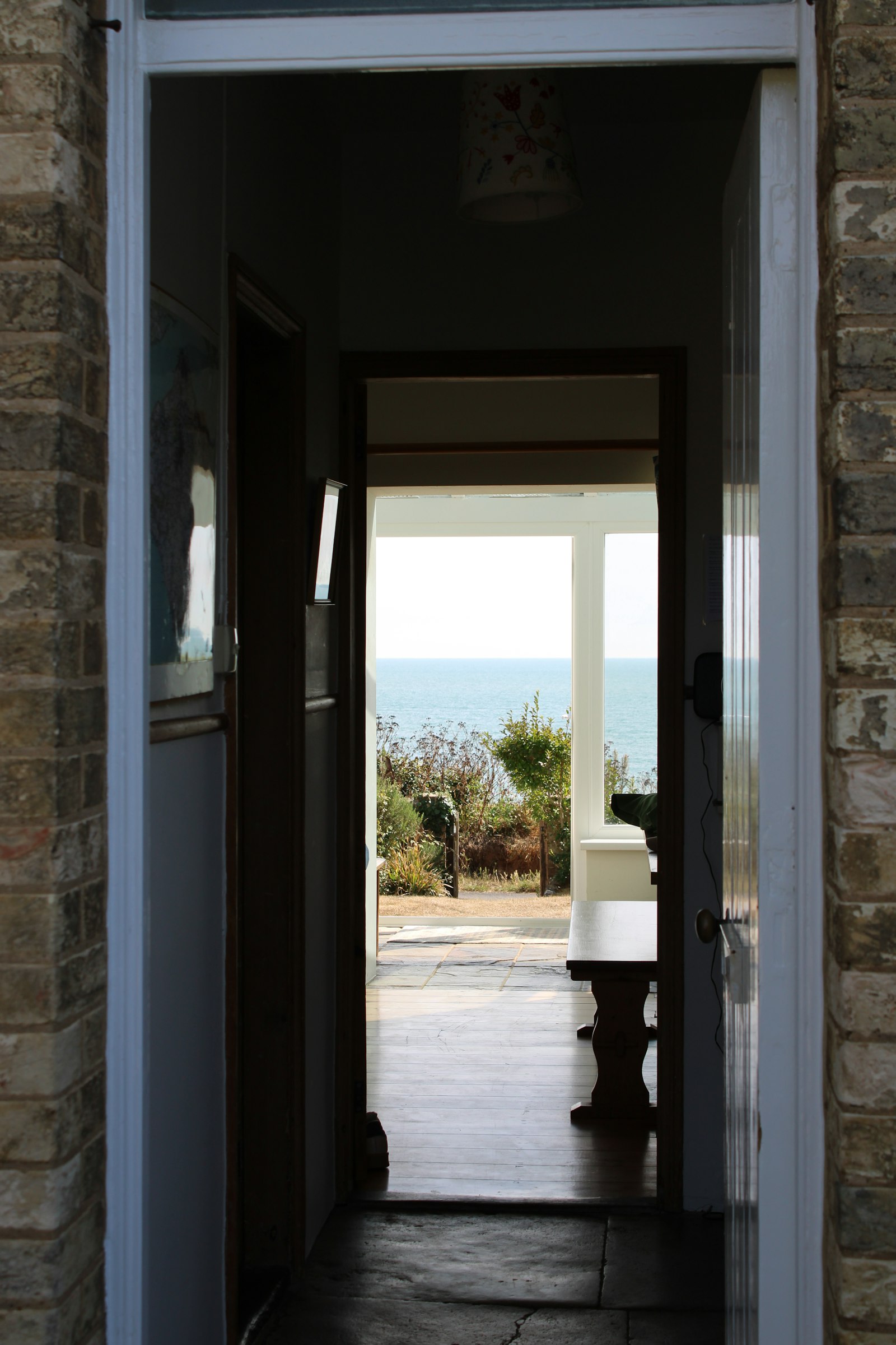 A view through the open doors of a family house to the garden and the sea