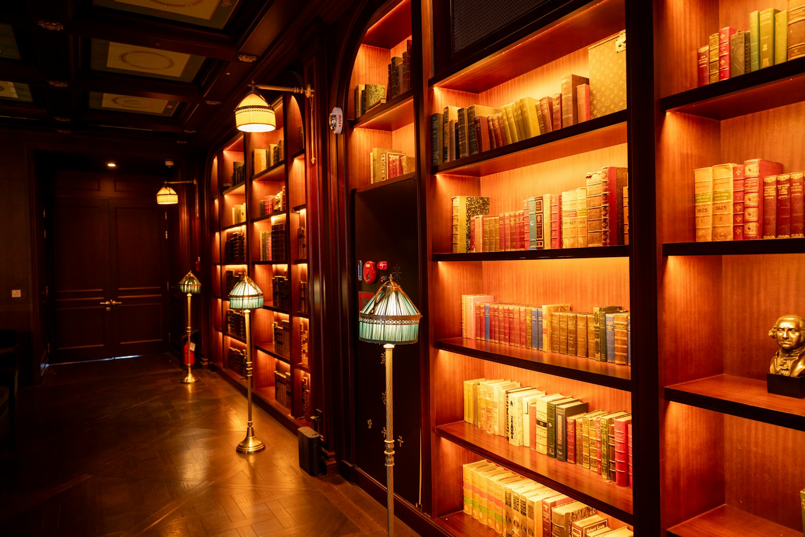 An intimate wood-panelled library in amber light